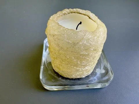 Rustic Candle in Glass Plate on Dark Surface Stock Photos