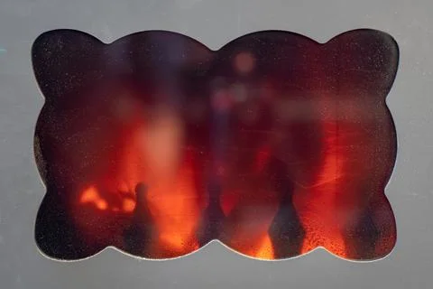 Rustic cast iron stove window where you can see the fire burning inside. Stock Photos