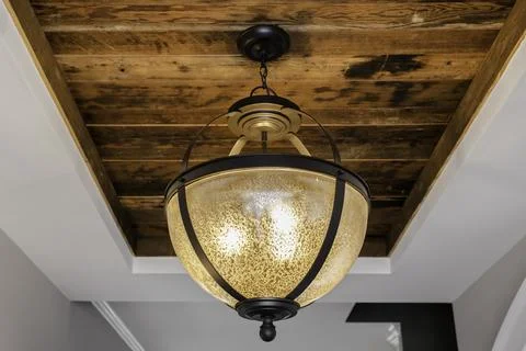Rustic Ceiling Light Fixture In A Home With A Wooden Ceiling Detail. Stock Photos
