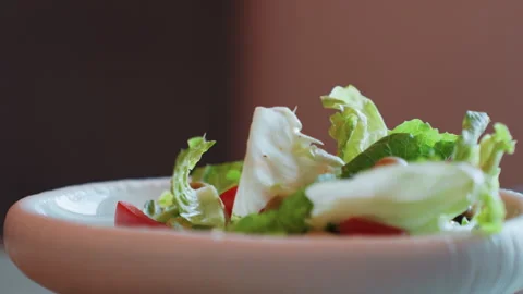 Rustic ceramic bowl salad closeup cozy, torn lettuce leaves and tomato wedges 库存影片 333472818