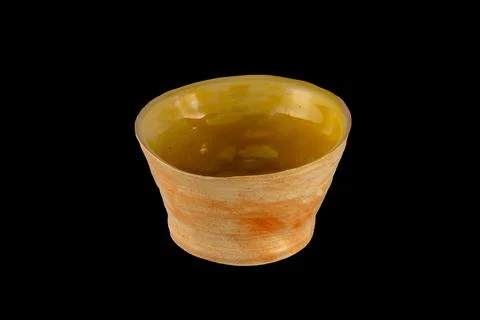 Rustic Ceramic Bowl With Yellow Glaze and Terracotta Exterior on Black Back.. Stock Photos