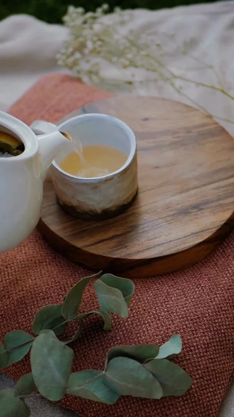 A rustic ceramic cup on a wooden tray with eucalyptus leaves and a linen cloth Video stock 344852590