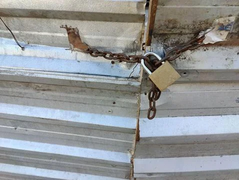 Rustic chains and padlock on metal wall Stock Photos