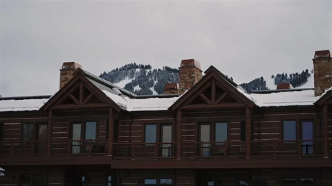 Rustic Chalets with Snowy Peaks Behind in Wyoming Stock Footage 309858086