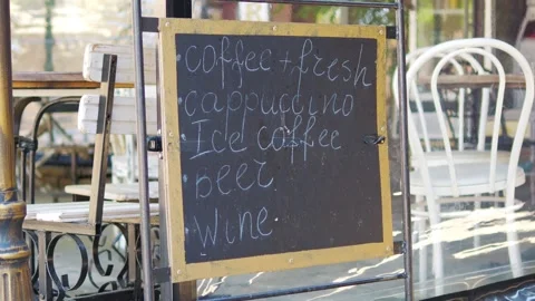 Rustic chalkboard menu outside a cozy caf, listing drinks like coffee, capp.. Stock Footage 292997727