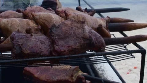 Rustic charcoal grilled meat with a tropical Caribbean beach background Stock Footage 337910021
