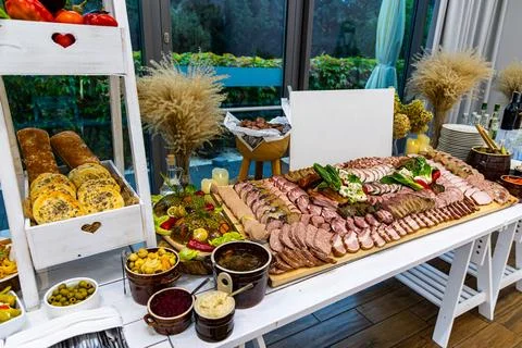 Rustic charcuterie buffet table with bread and pickles. Traditional-style buffet Stock Photos