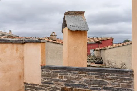 Rustic Chimney and Rooftops Under Cloudy Sky 스톡 사진