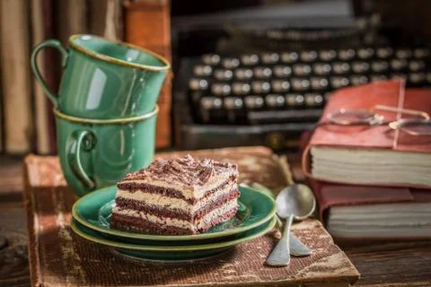 Rustic chocolate cake and coffee with books and typewriter Stock Photos