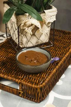 Rustic Chocolate Spread in Bowl on Wicker Tray with Lace-Lined Planter Decorativ Stock-Fotos
