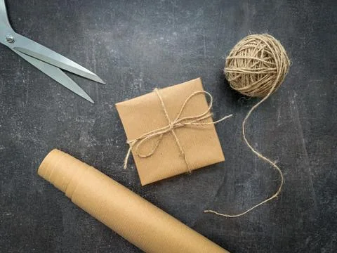 Rustic christmas gift wrapping workspace with craft paper, twine and scissors. Stock Photos