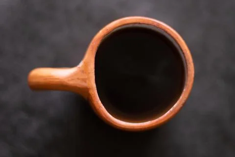 A rustic clay cup filled with hot coffee, viewed from above. Stock Photos