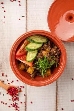 Rustic clay pot with stewed meat potatoes vegetables Stock Photos