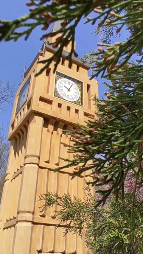 Rustic clock tower amidst trees with clock, in a serene park setting Stock Footage 272227319