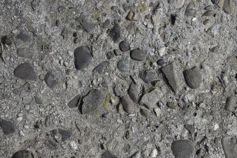 Rustic concrete texture with embedded river stones and pebbles Stock Photos