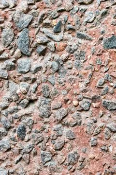 Rustic concrete wall facing by small rocks. Stock Photos