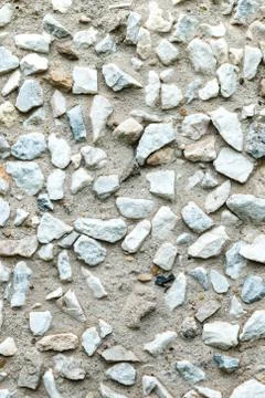 Rustic concrete wall facing by small rocks. Stock Photos