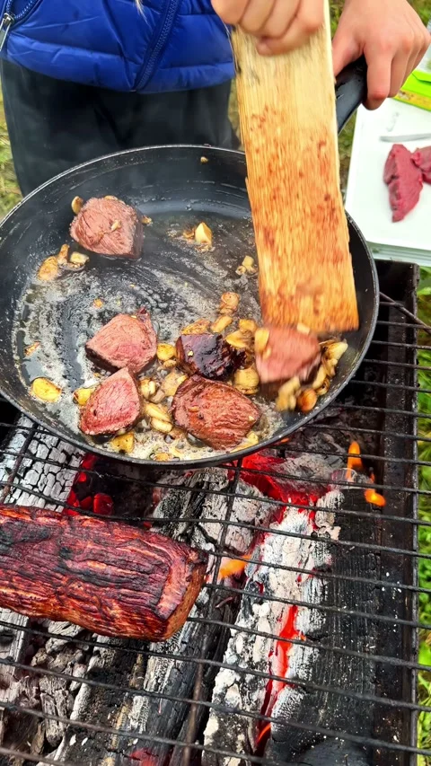 Rustic cooking over BBQ barbecue charcoal log fire beef meat in pan with tallow 스톡 동영상 348421931