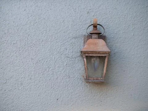Rustic copper lamp attached outside a house on white wall Stock Photos