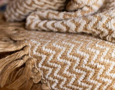 Rustic cotton zig zag woven blanket with beige bangs. Foto stock