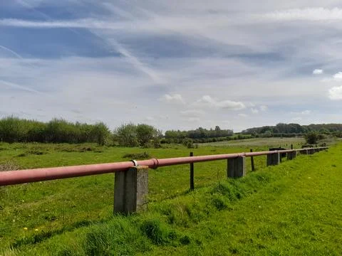 Rustic Countryside with Elevated Pipeline and Lush Green Field Stock Photos