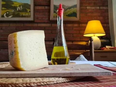 Rustic countryside table with cheese and oil Stock Photos
