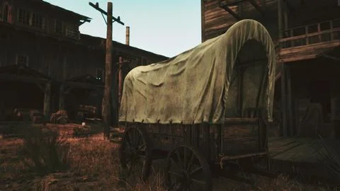 A rustic covered wagon in a serene field beside a charming building Ilustración de archivo