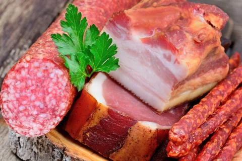 Rustic cutting board with prosciutto, salami, sausages and bacon Stock Photos