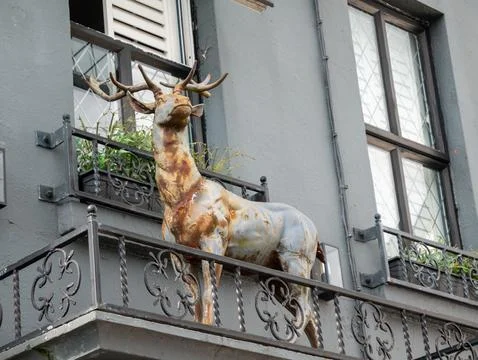 Rustic deer statue on urban balcony 库存照片