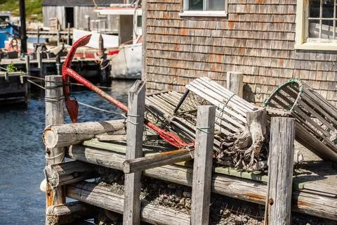 Rustic, dilapidated dock with gear and a red anchoe Stock Photos