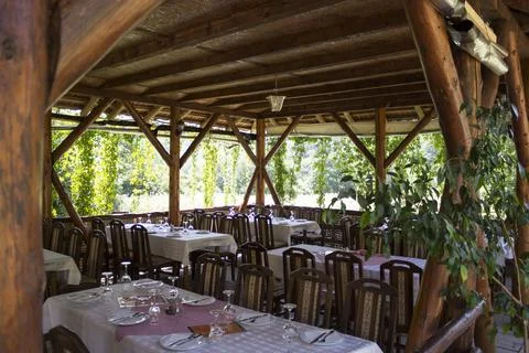 Rustic dining area in a countryside restaurant surrounded by greenery and s.. Stock Photos