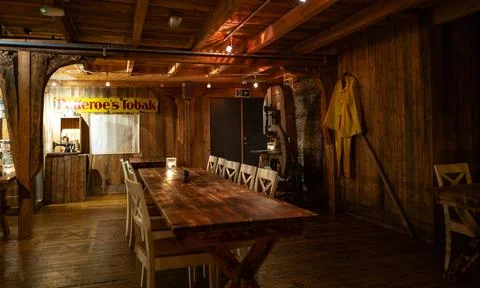 Rustic dining area with wooden table, white chairs, wall decor, Lofoten, Norw Fotos de archivo