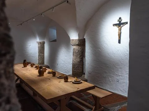 Rustic Dining Room with Clay Dishes and Crucifix Stock Photos