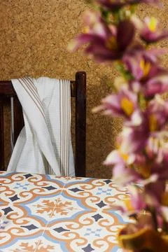 Rustic Dining Table with Patterned Tile Surface, Wooden Chair, Striped Towel and Stock Photos