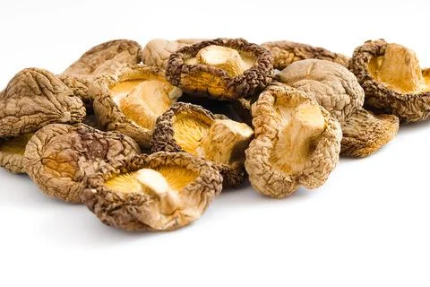 Rustic dried shiitake mushrooms set on a white background, revealing their .. Stock Photos
