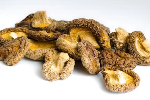 Rustic dried shiitake mushrooms set on a white background, revealing their .. Stock Photos