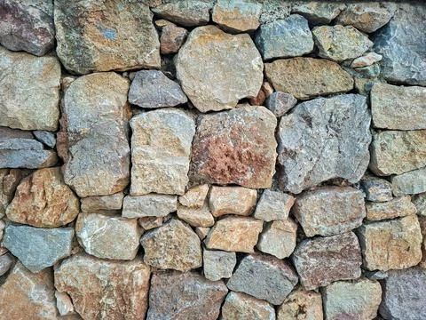 Rustic dry stone wall built with various rocks in a natural setting showcas.. Stock-Fotos