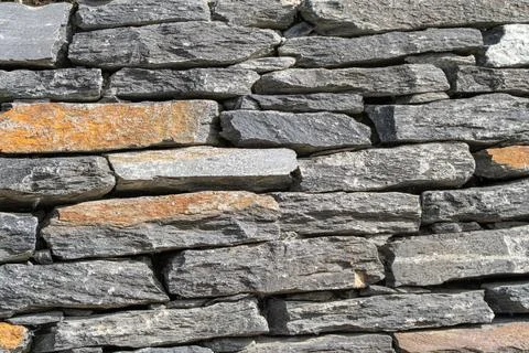 Rustic Dry Stone Wall Texture with Gray and Orange Natural Rocks Stock Photos