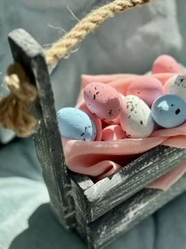 Rustic Easter Basket with Colorful Eggs on Pink Fabric Stock Photos