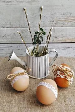 Rustic Easter composition with decorated eggs and watering can Foto stock