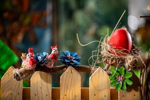 Rustic Easter Composition: Handcrafted Nest, Red Egg, and Whimsical Bird Figures 스톡 사진
