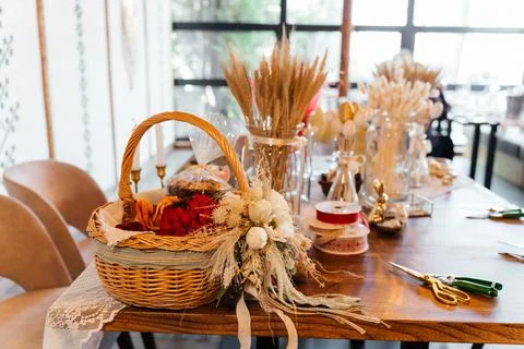 Rustic Easter craft table with wicker basket, dried flowers, and handmade Stock Photos