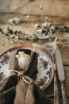 Rustic Easter table setting. Natural egg in napkin with flowers, setting  w.. Stock Photos