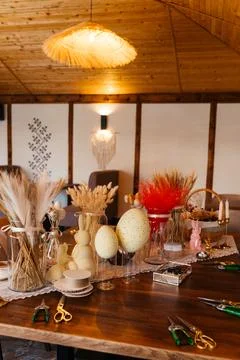Rustic Easter-themed craft table decorated with dried flowers, wheat, and Stock Photos