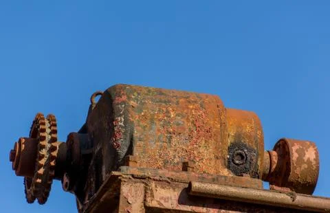 Rustic electric motor covered in rust on a blue background Stock Photos