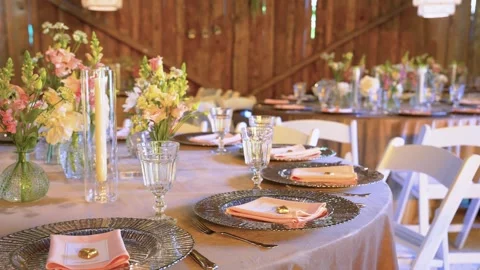 Rustic Elegant Barn Wedding Reception Table Decor with Flowers and Glassware Stock Footage 338404212