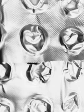 Rustic empty pill blister overlapping metallic texture background Stock Photos