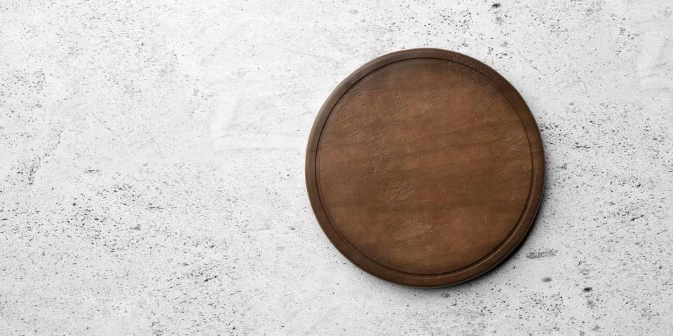 Rustic empty round wooden cutting or chopping board on concrete table backg.. Illustrazione stock
