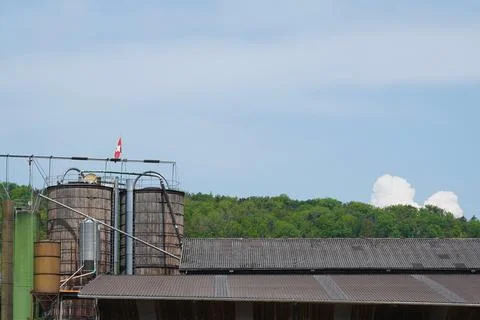 Rustic Farm Silos and Barn Roof with Green Trees and Blue Sky Stock Photos