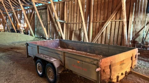 Rustic Farm Trailer in Old Barn with Hay Creates a Calm Rural Ambiance Stock Footage 333310693